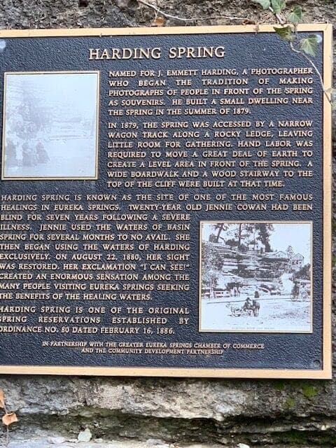 A historical plaque detailing the significance of Harding Spring and its association with healing and photography in Eureka Springs.