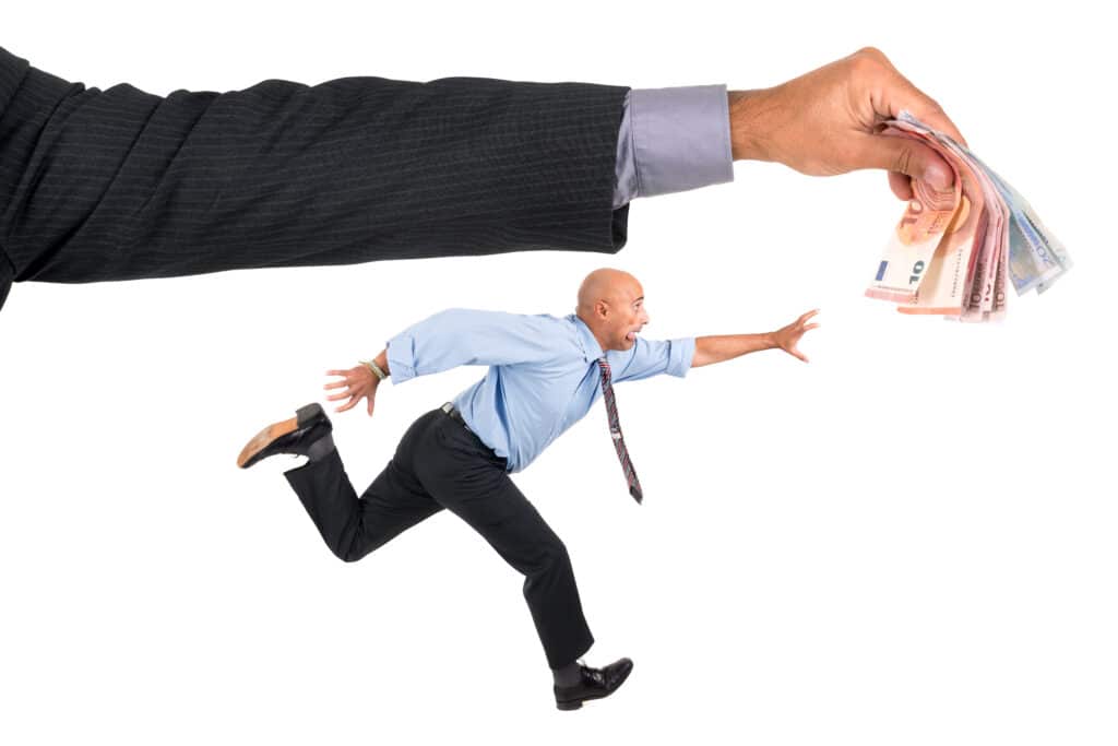 A businessman reaches for money being offered while running away.