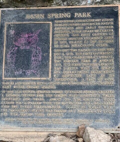 A brass plaque detailing the history and significance of Basin Spring Park.