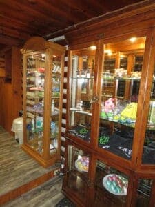 Two wooden display cabinets filled with colorful items and merchandise in a cozy interior setting.