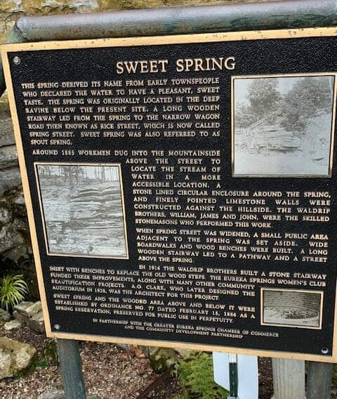A historical plaque describing the origins and developments of Sweet Spring, including its water's pleasant taste and the construction work done in 1885 and 1916.