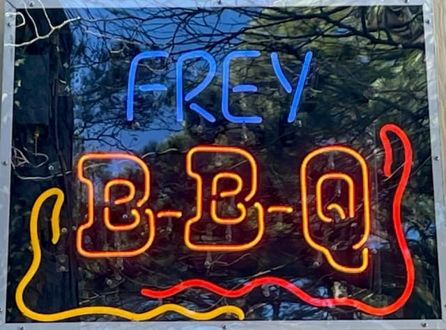 Neon sign reading "Frey BBQ."