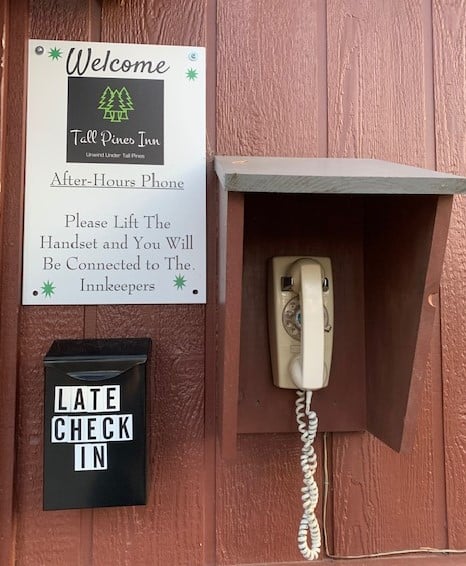 Wall with late check in box signage and phone