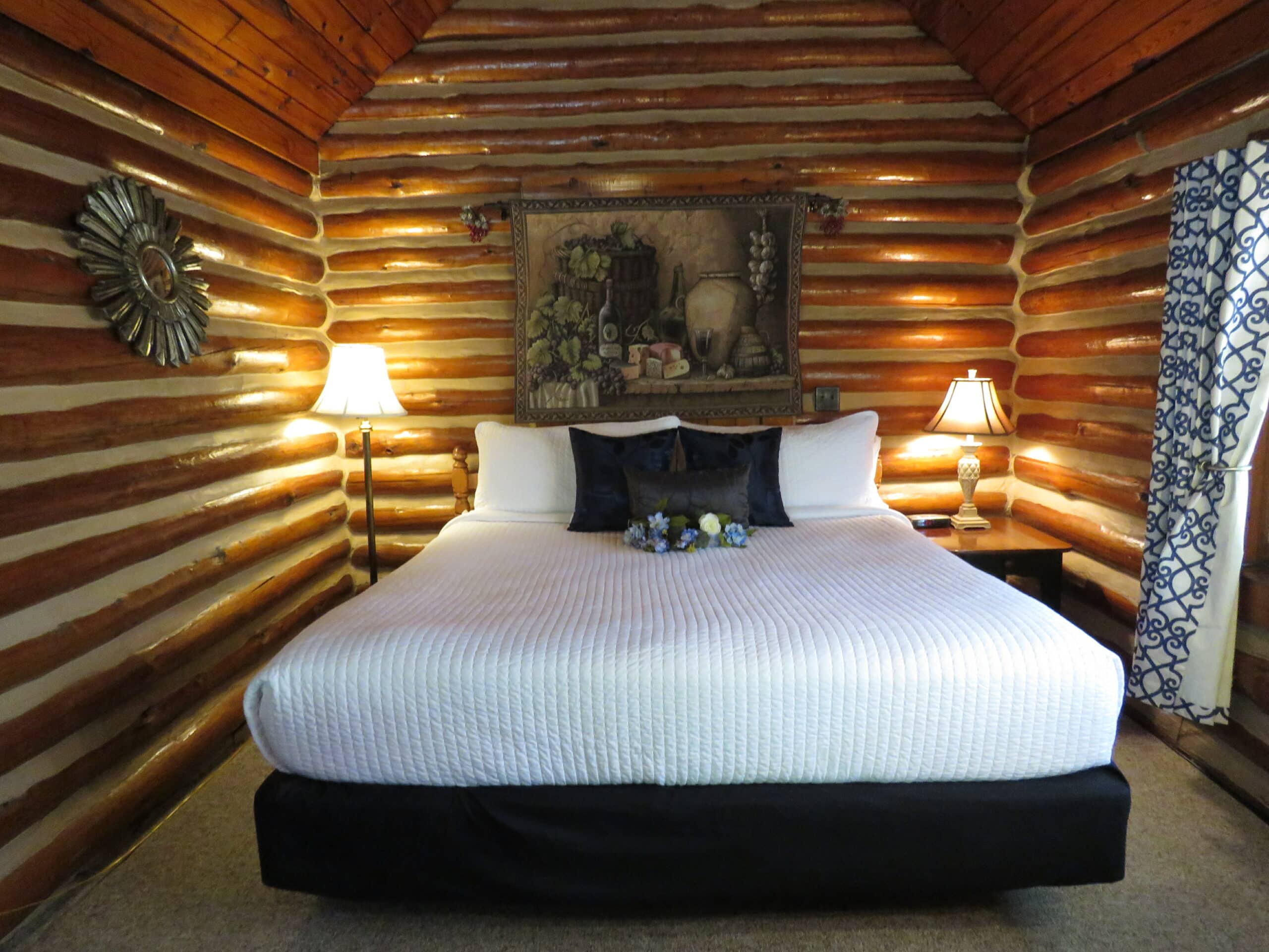 King bed in a log lodge cabin with side table lamps on