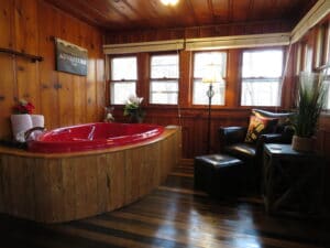 cabin with hardwood floors and red jetted tub