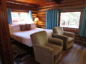 cabin with king bed and two swivel chairs