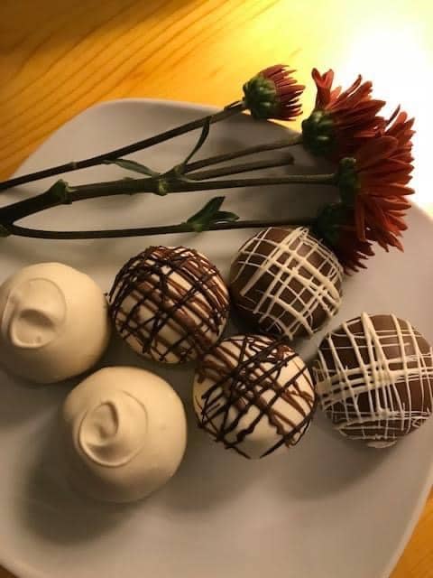 truffles on a plate with a flower next to it