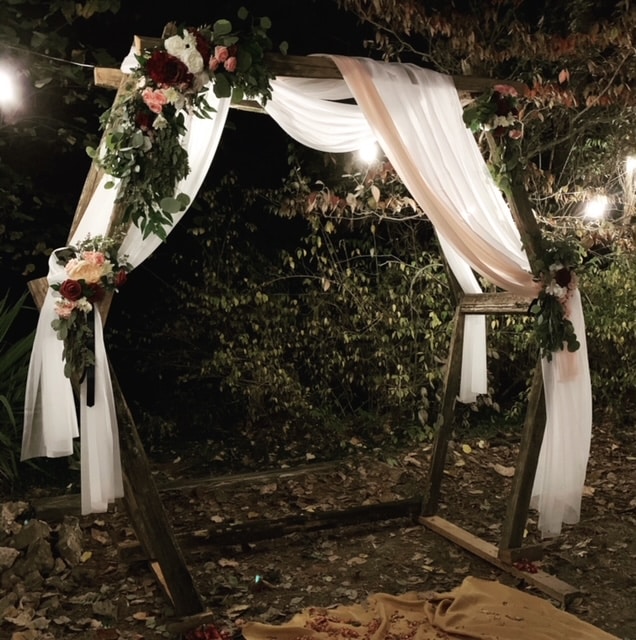 rustic wedding arch at nighttime