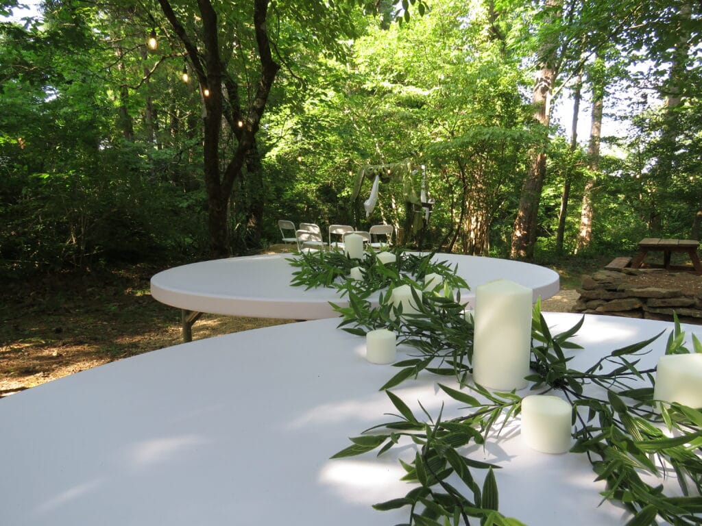white round wedding tables decorated tables in various green foliage colors and white candles