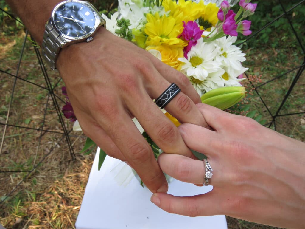 bride and groom joining hands in front of their bouquet