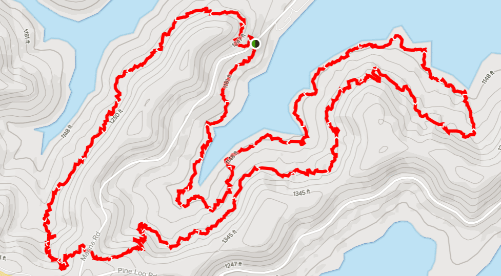 hiking trail marked in red around a lake