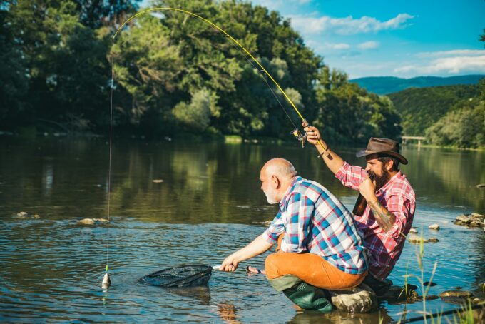 Mature senior man with friend fishing. Summer vacation. Happy cheerful people. Bearded men catching fish. Fisherman with fishing rod. Activity and hobby.